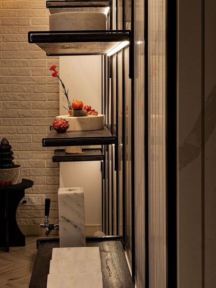 A detail shot of our custom shelving against a white brick-textured wall. The contrast between the rustic brick and the sleek, dark shelves creates a balanced composition, showcasing our ability to blend different materials effectively.