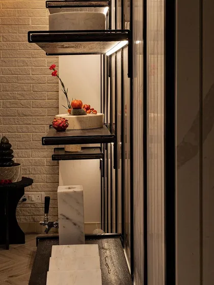 A detail shot of our custom shelving against a white brick-textured wall. The contrast between the rustic brick and the sleek, dark shelves creates a balanced composition, showcasing our ability to blend different materials effectively.