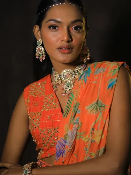 The model strikes a pose, showing how this statement choker can elevate a simple, vibrant outfit.