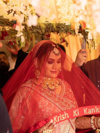 The bridal entry under the phoolon ki chadar. The makeup is designed to look magical in every lighting, from daylight to the warm glow of the ceremony.