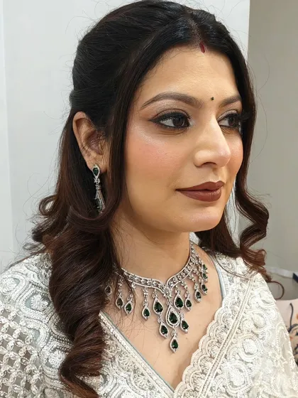 A classic half-up, half-down hairstyle with soft curls at the ends. This look is perfect for a wedding guest, offering an elegant way to keep hair off the face while still showing off its length.