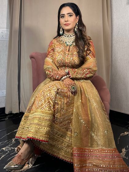 A full shot of the client looking regal in a Rimple & Harpreet outfit, her makeup glowing with precision.