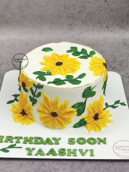 A simple and sunny sunflower cake. The hand-piped sunflowers on this cake create a bright and happy design.