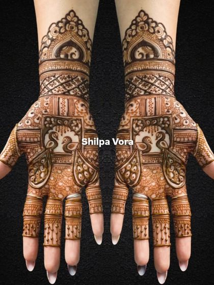 A symmetrical bridal design featuring peacocks in jharokhas and elephants on the wristband.