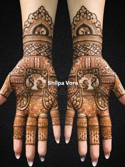 A symmetrical bridal design featuring peacocks in jharokhas and elephants on the wristband.