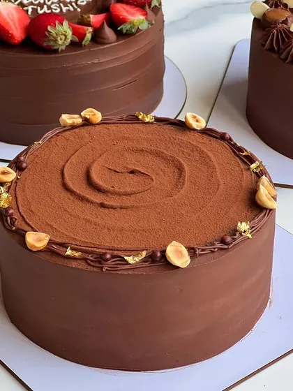 A close-up of my Hazelnut Praline Feuilletine cake, finished with a dusting of cocoa powder and toasted hazelnuts. The texture and flavor are just divine.
