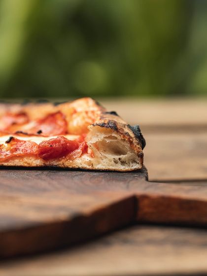 Another look at the beautiful, open crumb of our sourdough crust. The slight char from the wood-fired oven adds a smoky depth to the tangy flavor of the dough.