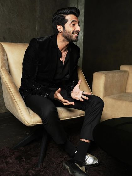 A wider shot that shows more of the environment and captures an expressive, conversational pose.