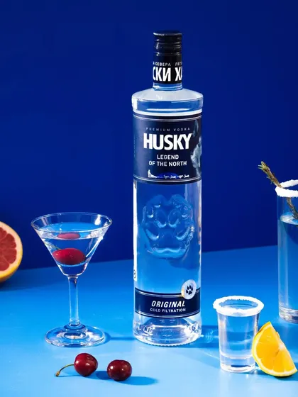 A premium studio shot for a vodka brand, using a bold, monochromatic blue background to match the product's branding. We styled it with classic cocktails and fresh fruit garnishes to create a crisp, clean, and sophisticated image.