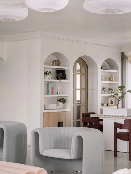 The dining area and living room of Eden House, showing the arched doorways and built-in shelving that add architectural interest. The space is open and flowing, perfect for entertaining and family life.