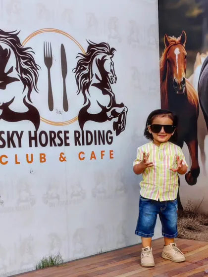 Our venue is a hit with all ages. This young guest is striking a pose in front of our branded photo wall, a popular spot for capturing memories during family parties and events.