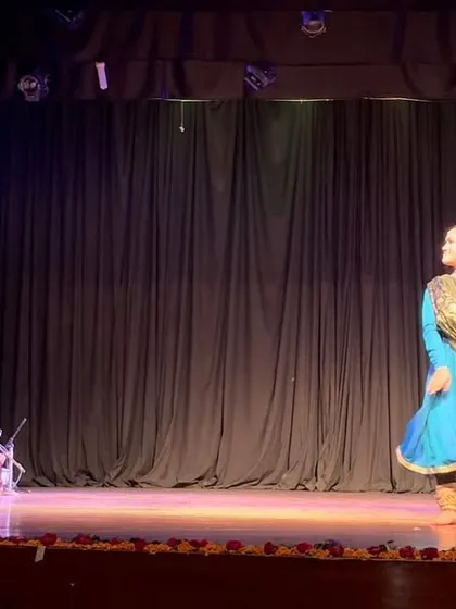 A wide view of the stage, showing the dancer in motion with the live band.