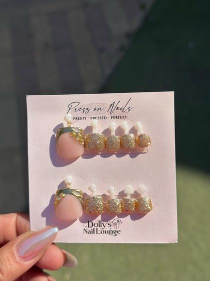 A glamorous press-on set for toes with a gold glitter finish and an elegant gold leaf design on the big toe.