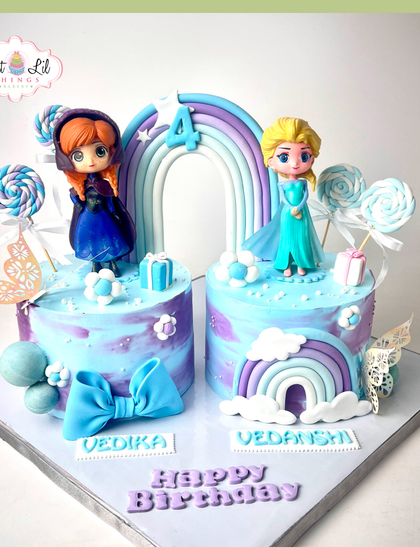Double the magic with this twin Frozen-themed birthday cake. Featuring both Elsa and Anna on separate mini-cakes, this creation is adorned with rainbows, bows, and candy for a sweet 4th birthday.
