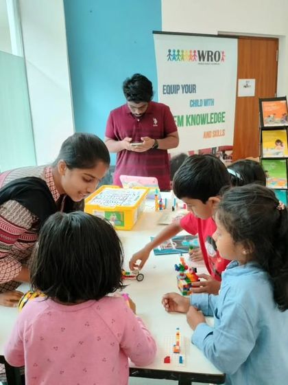 A group of children gathers around a table at our Total Environment event, excited to build and create with our LEGO Education kits.