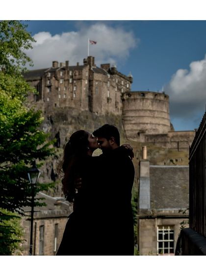 A stunning silhouette of the couple sharing a kiss, with the historic Edinburgh Castle in the background. This is a truly epic and romantic shot, perfect for a destination pre-wedding album.