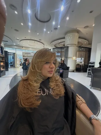 A side view of the blonde, face-framing layers. This angle shows off the beautiful shape of the haircut and the brightness of the color.