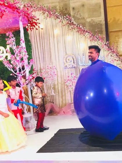You must have this Balloon Act for a blasting day! A performer inside a giant blue balloon entertains a group of children at a beautifully decorated party.