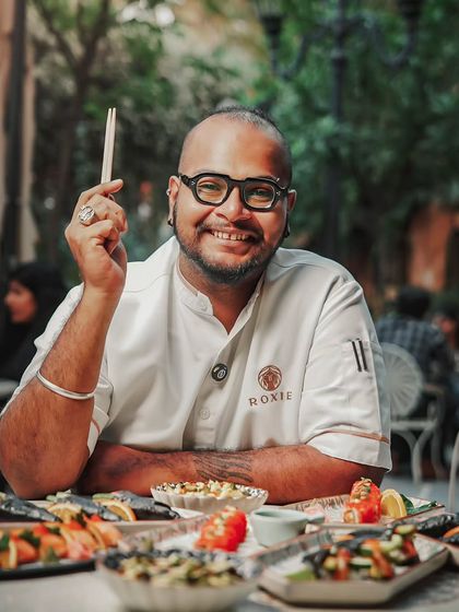 Chef Viveq, the artist behind our sushi menu, surrounded by his creations. His passion is evident in every roll.