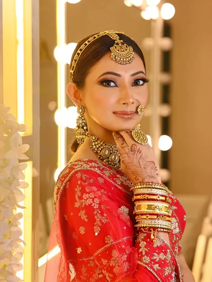 A sleek and polished low ponytail secured with a traditional matha patti. This look is a modern take on bridal hair, perfect for the bride who wants something unique yet elegant.