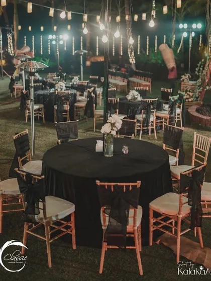 For this 'unplugged night' reception, I used elegant black tablecloths and simple white floral centerpieces, with strings of Edison bulbs overhead to create a warm, intimate, and sophisticated ambiance.