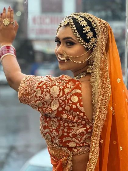 A side profile of our beautiful Marwadi bride. You can see the intricate details of her headpiece, the traditional nath, and the soft glam makeup that enhances her features while respecting tradition.