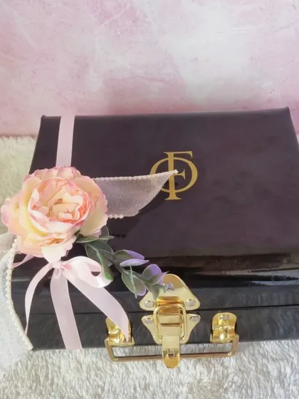 The elegant black trunk box used for our luxury Mother's Day hampers, adorned with a flower and ribbon.