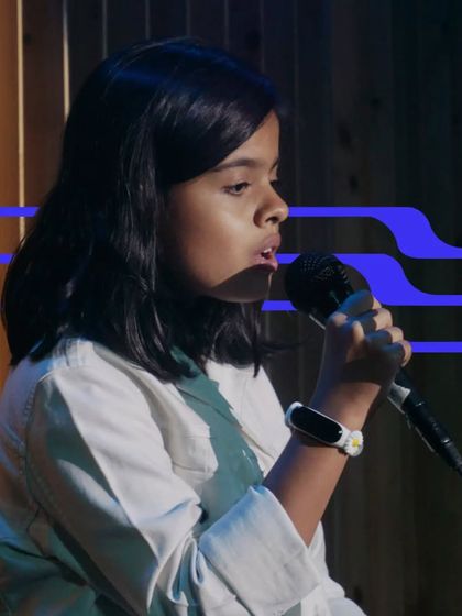 A young girl sings with focus and emotion. Our vocal lessons help students of all ages develop their voice and performance skills.