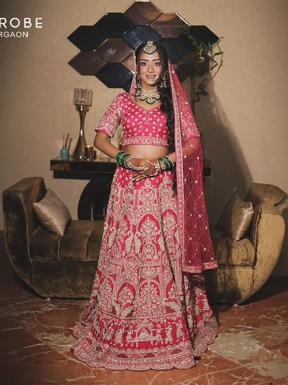 This full-length shot showcases the beautiful flare and detailed work of the pink bridal lehenga. It's a perfect blend of tradition and modern elegance.