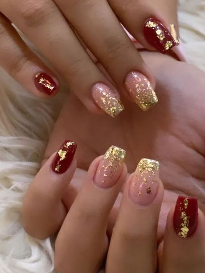 A festive combination of deep red and gold foil on square-shaped nails, perfect for the holiday season or any celebration.