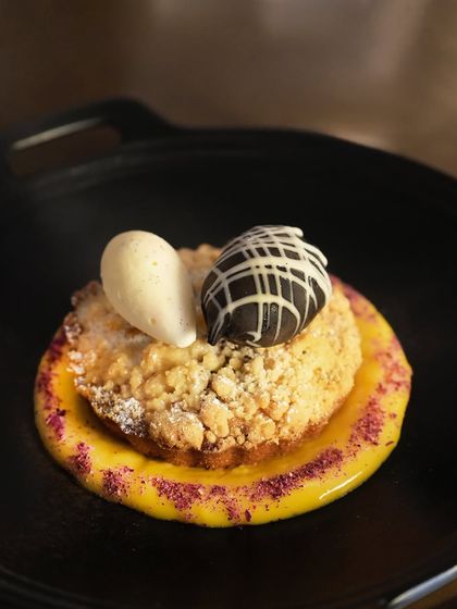 A close-up of the Valentine's Day special dessert, showcasing the delicate crumble, rich mawa cake, and a scoop of luxurious champagne ice cream.