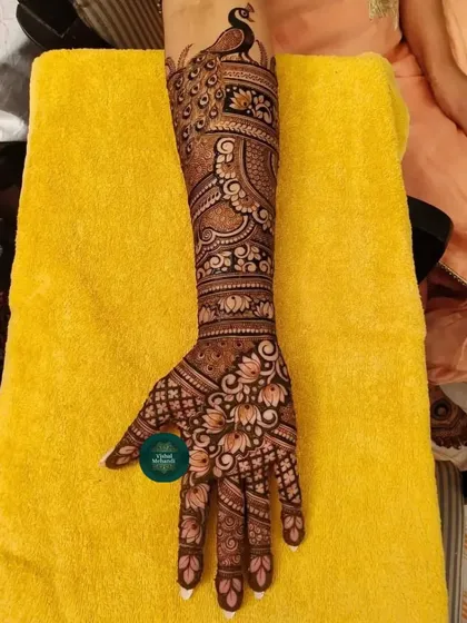 An elegant single-arm design featuring a beautiful peacock at the top, with lotus and floral patterns flowing down to the hand.