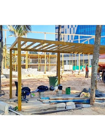 An identical shot of the pergola construction, with the surrounding palm trees already in place.