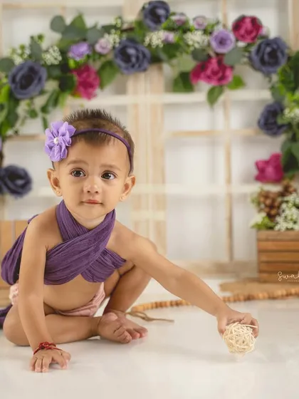 Exploring her surroundings during her lavender-themed first birthday shoot. These curious moments make for beautiful candid photos.