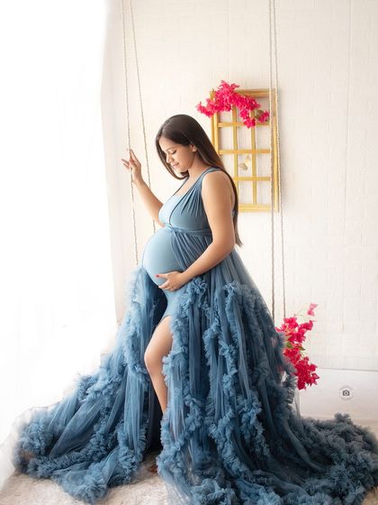 A beautiful solo portrait on the studio swing. The flowing blue gown drapes elegantly, creating a dreamy and ethereal image.
