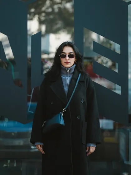 A shot of the model standing in front of a modern glass building. This image has a sleek, urban vibe, perfect for a contemporary fashion portfolio.
