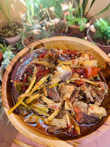 A comforting bowl of beef bones cooked in a hearty broth with bamboo shoot stem, dried cauliflower stem, and brinjal.