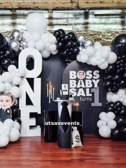A stylish Boss Baby themed first birthday in black and white. The setup includes large 'ONE' letters and character cutouts for a sharp, modern look.