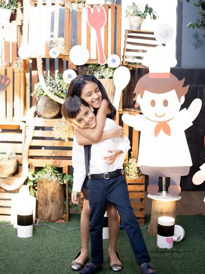 Even in the middle of a lively party, we can find a moment for a lovely sibling portrait. This photo captures the sweet and playful bond between a brother and sister against the backdrop of their fun party theme.