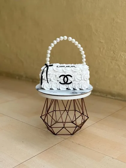 Yes, this is 100% a cake! We had so much fun sculpting this Chanel-inspired purse cake, complete with a pearl handle and rosette-style buttercream. Our workshops explore how to carve and structure novelty cakes that look just like the real thing.
