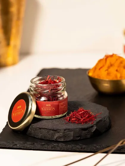 This shot shows the saffron both in its raw form and prepared as a paste. This helps customers understand the product's versatility and use in cooking, set against a warm and inviting background.