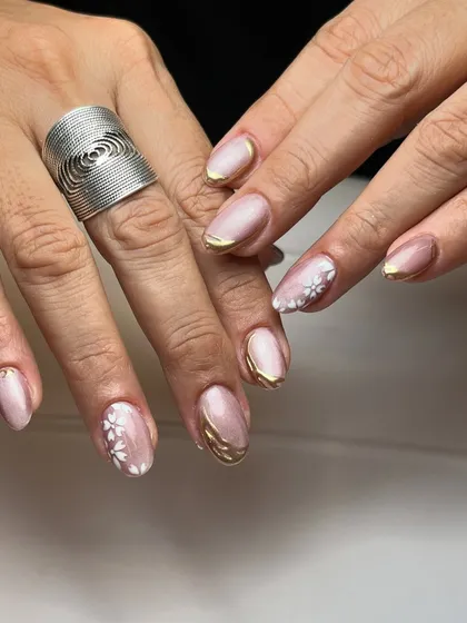 A pinch of art. This design combines a soft pink cat-eye base with hand-painted white flowers and a bold gold chrome border for a unique, multi-textured look.