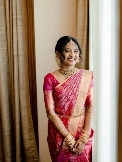 A series of photos capturing the grace of this South Indian bride. Her look features traditional temple jewelry, a silk saree, and a fresh, dewy makeup finish with a classic floral hair bun, embodying timeless elegance.