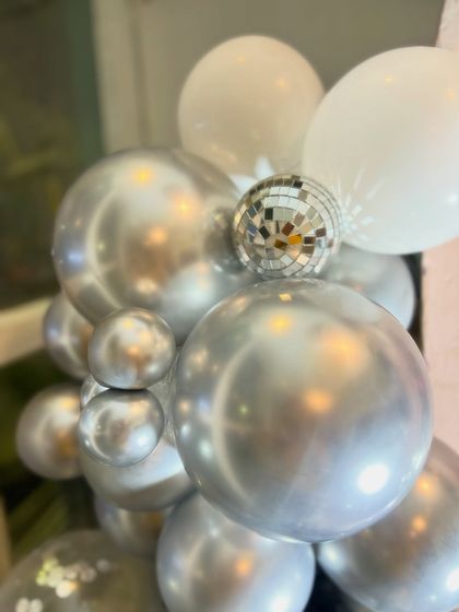 We added mini disco balls to the balloon arrangements for that extra bit of sparkle and fun, perfectly fitting the party theme.