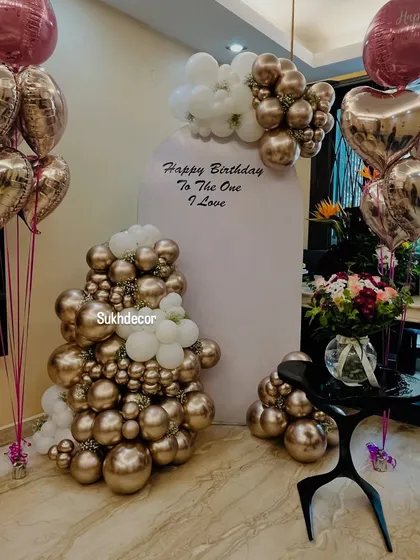 Another angle of the elegant birthday setup, highlighting the two bouquets of heart-shaped and round foil balloons that frame the central backdrop.