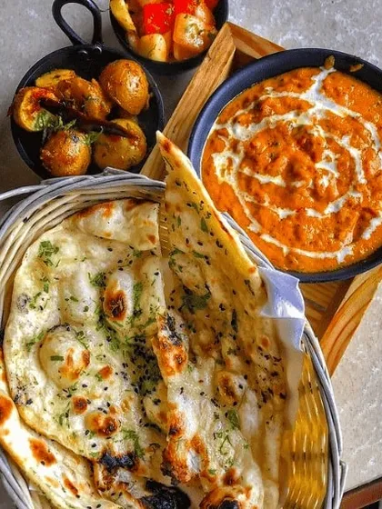 If you prefer to order exactly what you're craving, my à la carte menu is for you. Here you see our creamy Butter Paneer Masala served with hot, fluffy garlic naan and a side of spiced potatoes.