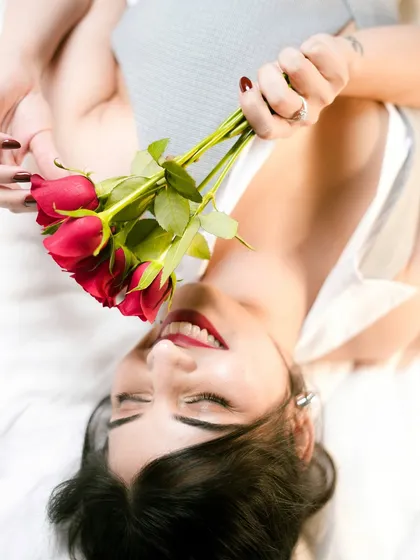 An artistic overhead shot from the "rose" photoshoot. The red lip and nails stand out, tying the whole romantic theme together.