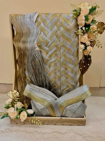 For the big Indian wedding, I specialize in exquisite trousseau packing. Here, I’ve arranged beautiful garments in a decorative wooden tray, adorned with delicate floral arrangements to make the bride's collection feel even more special.