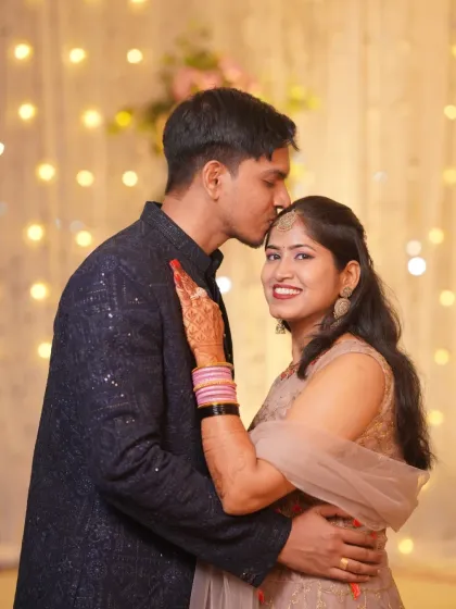 A warm and affectionate portrait of the newly engaged couple. The groom's gentle kiss on her forehead shows their deep connection.