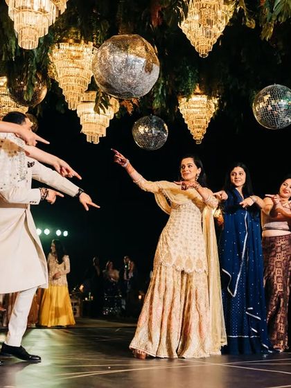 The groom points to the bride during a fun, interactive part of their group sangeet dance. These little details make the performance personal and engaging for the couple and their guests.